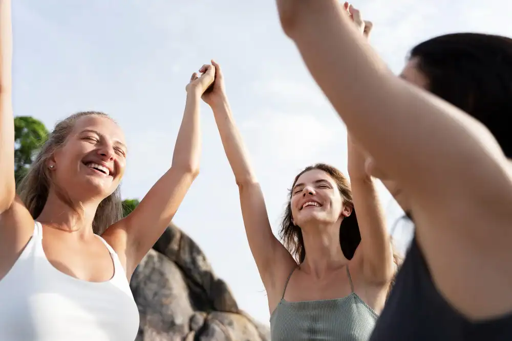 Women's Health Dietitians & Nutrition Support, In Good Nutrition, three women stand outdoors holding hands and raising their arms, smiling joyfully