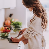 Pregnant women in kitchen cooking a healthy meal