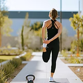 An athlete stretching post workout getting ready to refuel her body post workout